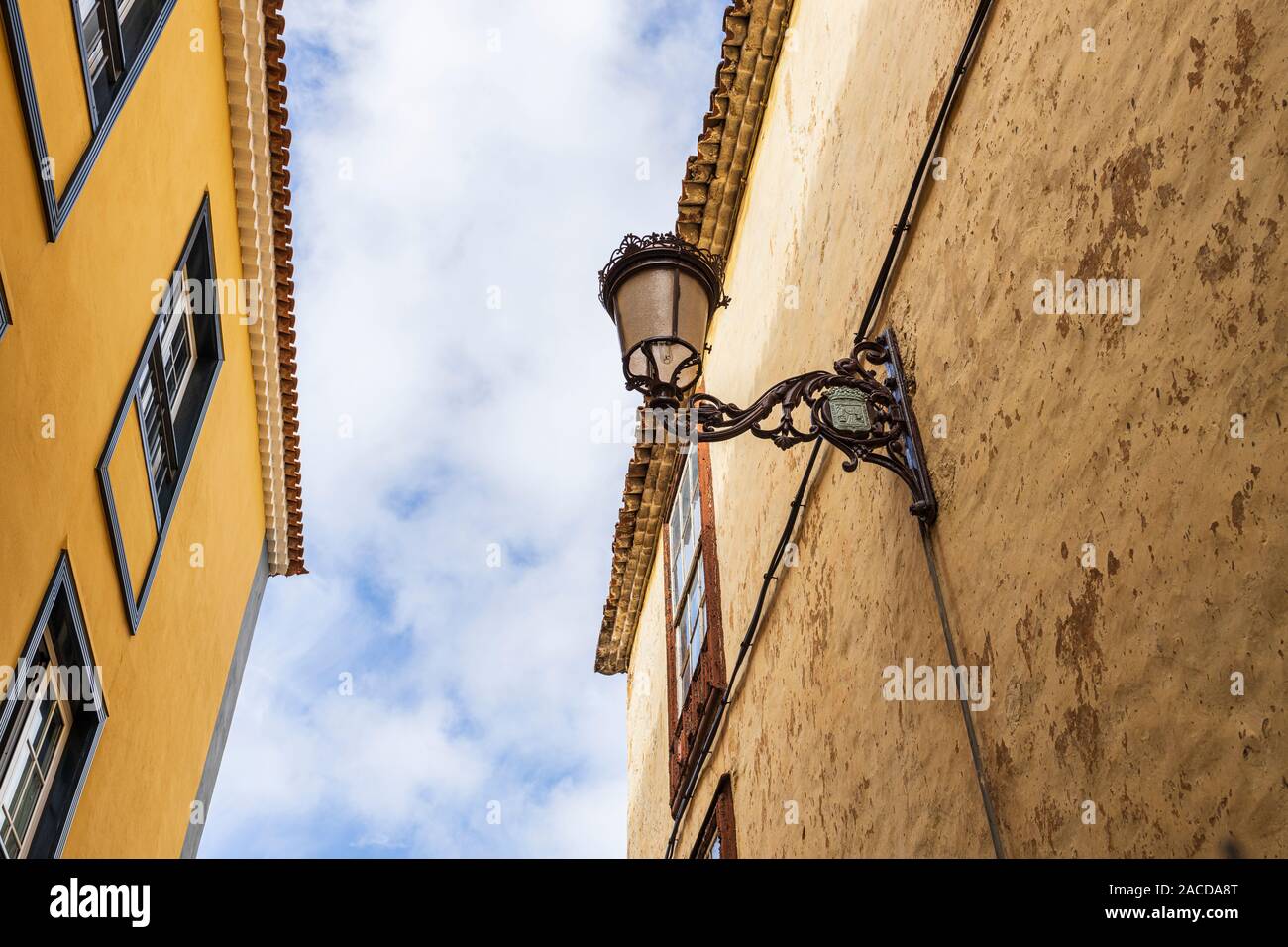 Vecchia strada lampada su un vecchio edificio di fronte alla più recente costruzione in un vicolo di San Cristóbal de La Laguna, Tenerife, Isole Canarie, Spagna Foto Stock