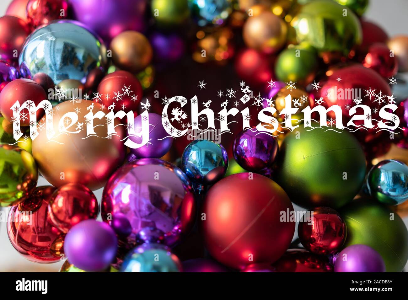 La decorazione della porta con coloratissime palle di Natale a casa porta con vetro frontale di giorno. Basso angolo di visione, vicino. Scheda di Natale: Buon Natale. Foto Stock