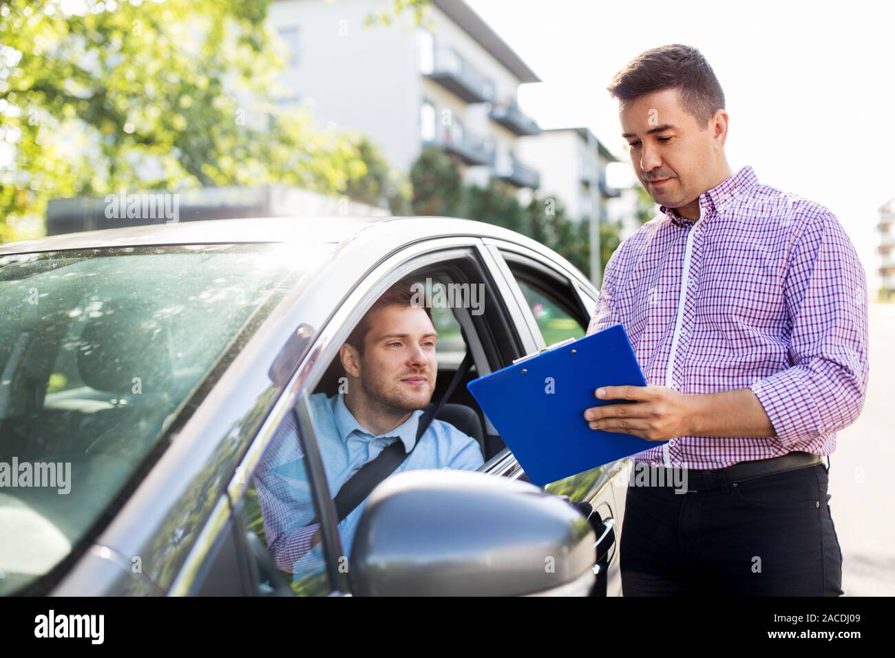 Guida auto istruttore con appunti e conducente Foto Stock