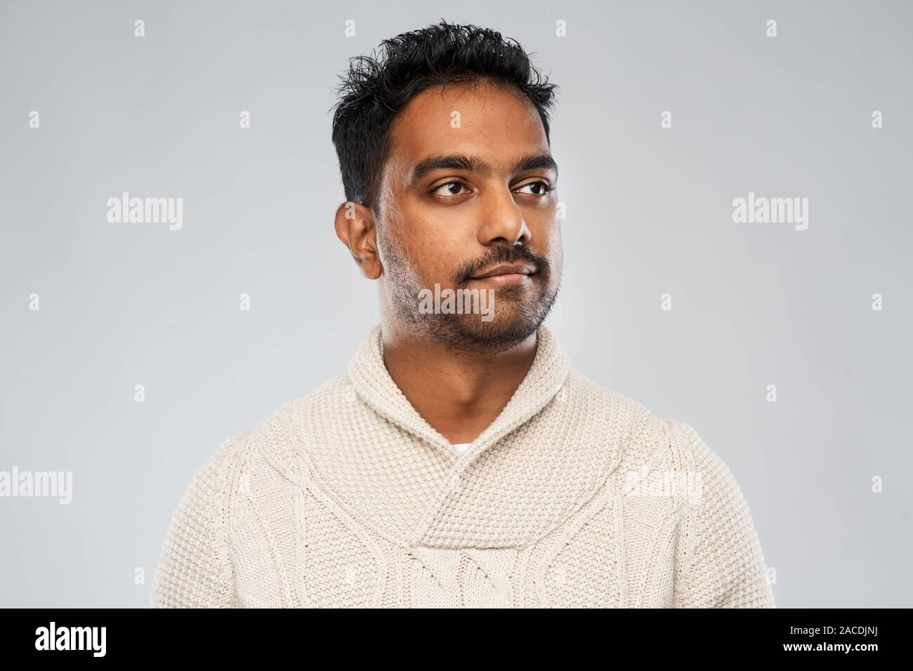 Indian uomo in felpa lavorata a maglia su sfondo grigio Foto Stock