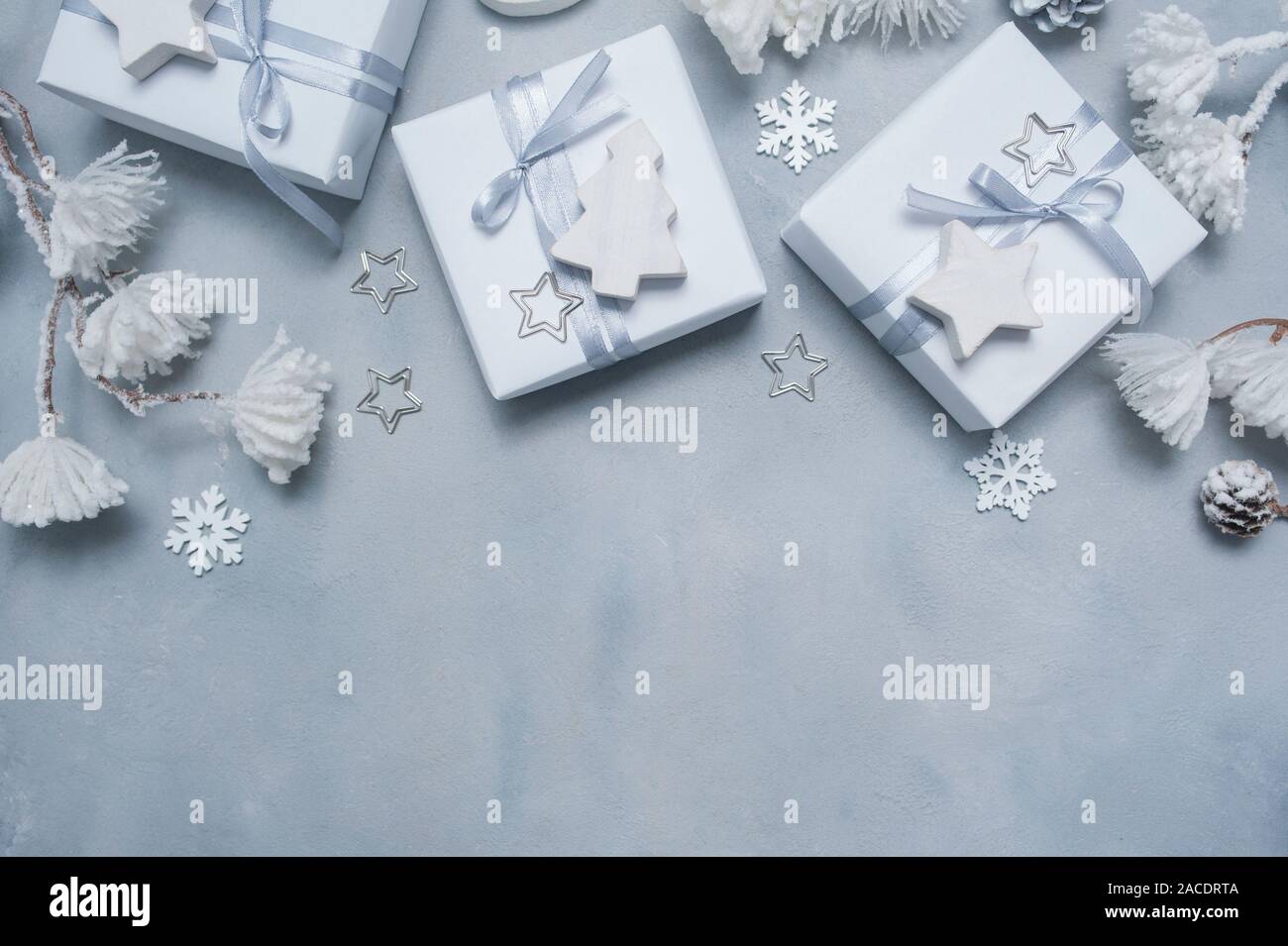 Progettazione di frontiera un Natale biglietto di auguri con il Natale regalo, coni, i fiocchi di neve con posto per il vostro testo. Decorazioni su un cemento bianco sullo sfondo Foto Stock