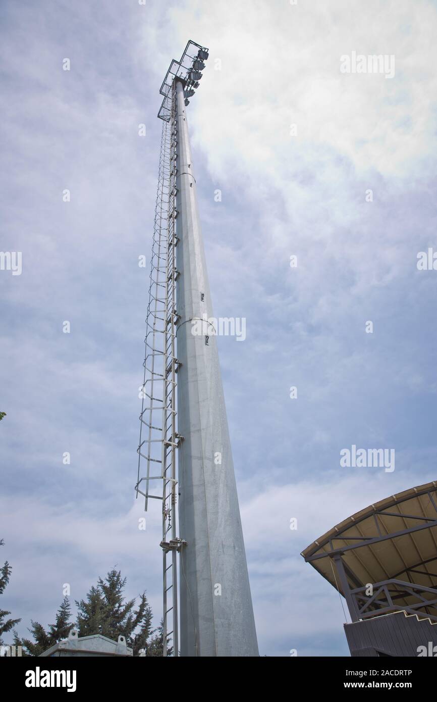 Pilastro faretti blu cielo . lampada posta ,industria elettrica, luce stadium o illuminazione sportiva isolata su sfondo blu.Stadium torre luci Foto Stock