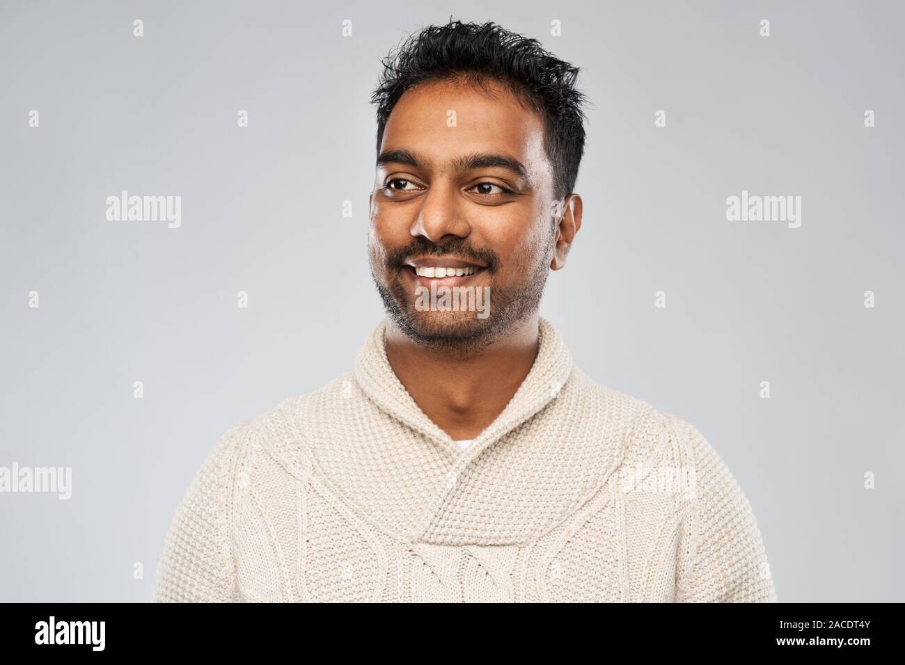 Indian uomo in felpa lavorata a maglia su sfondo grigio Foto Stock