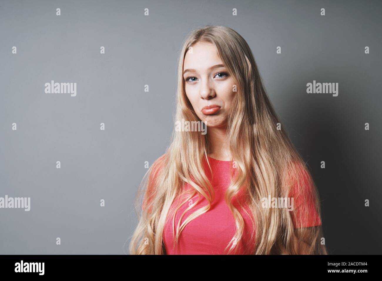 Sulky pouty ragazza adolescente esercitano le labbra l'adolescenza - Nozione - Sfondo grigio con spazio di copia Foto Stock