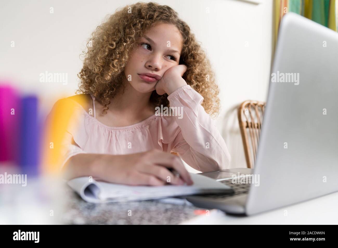 Ragazza annoiata che usa il computer portatile Foto Stock