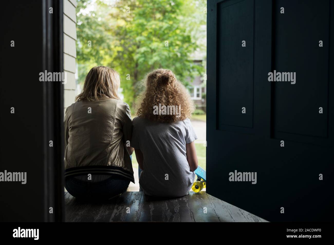 Madre e figlia seduti sul portico Foto Stock