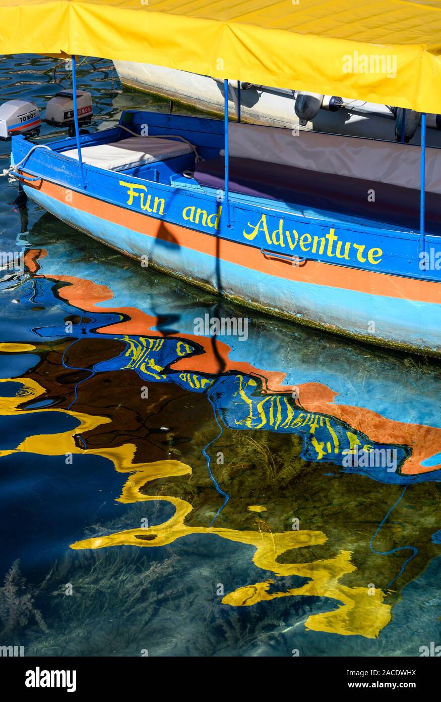 Un colorato tour in barca si riflette nell'acqua del porto della città di Ohrid sulla ther riva del lago di Ohrid in Macedonia nord, Europa. Foto Stock