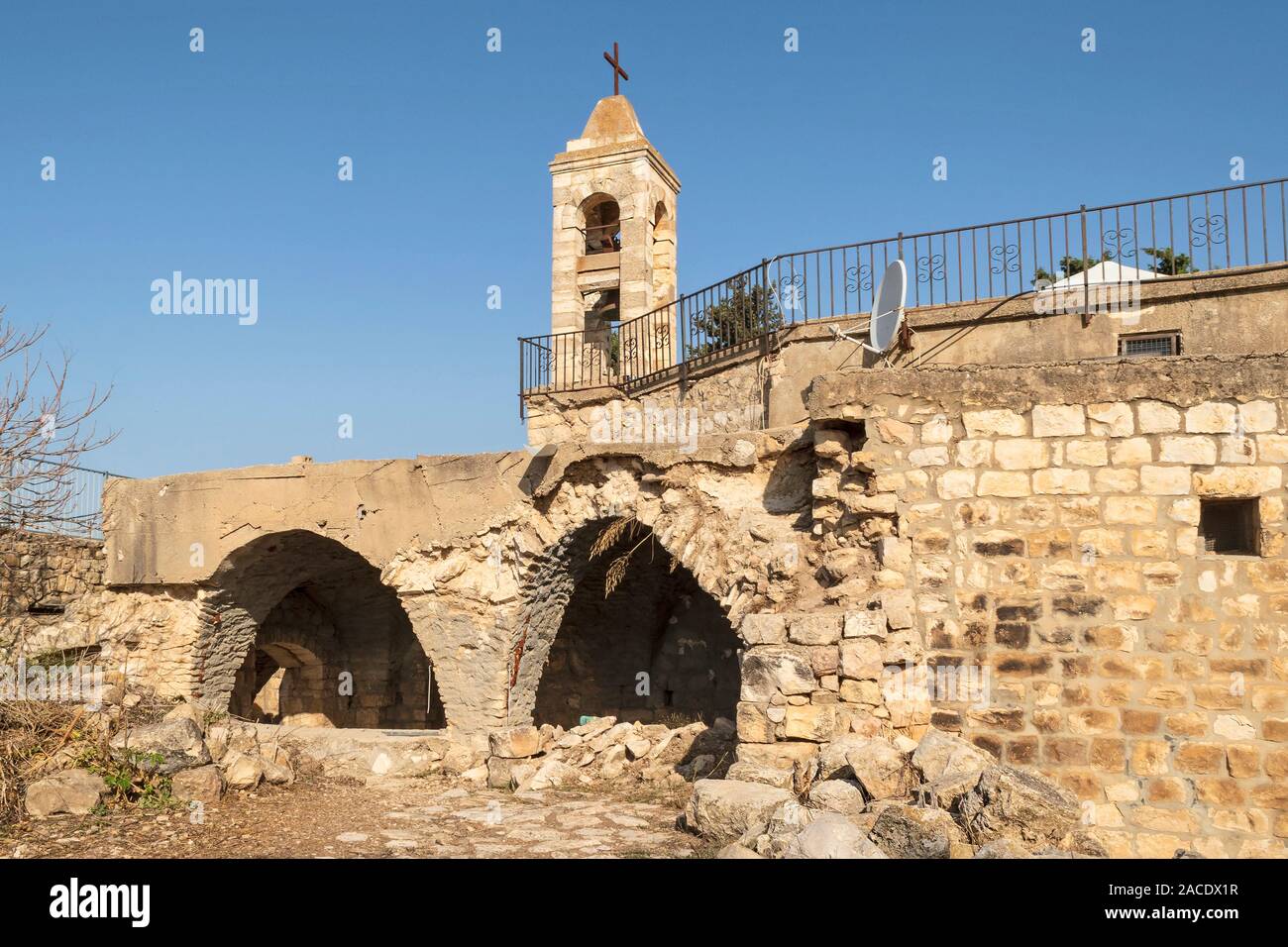 Retro della pietra antica chiesa maronita in bar l'am parco nazionale in Israele che mostra due archi e la torre campanaria con un cielo azzurro sullo sfondo Foto Stock