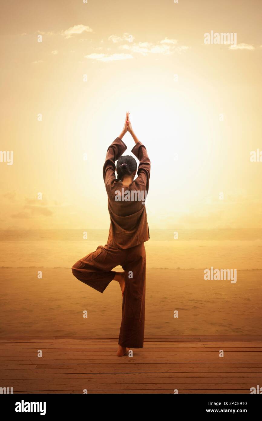 Donna che fa yoga sulla spiaggia in Atollo Sud Male, Maldive, Asia del Sud Foto Stock