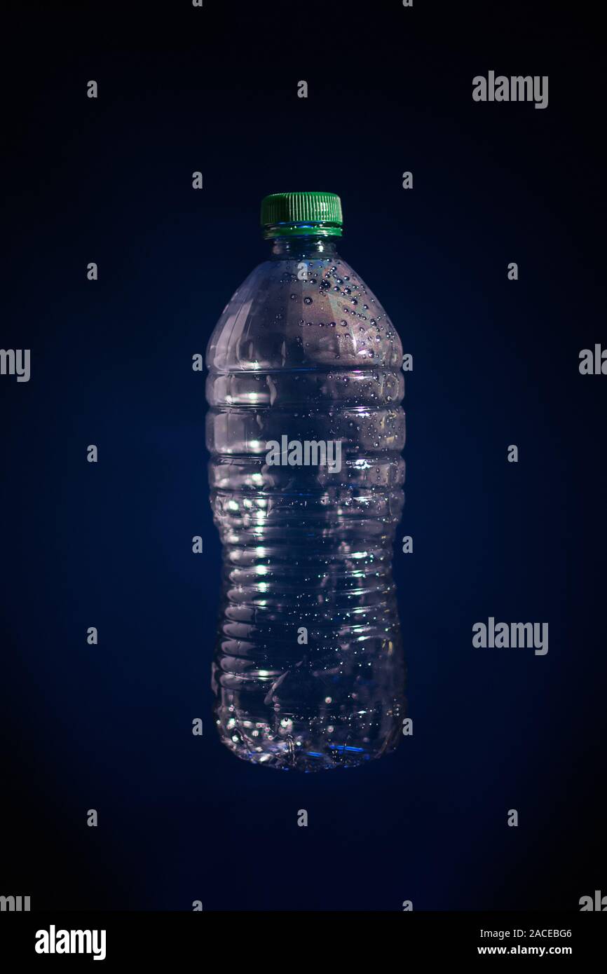 Silhouette di plastica trasparente bottiglia utilizzata su sfondo scuro Foto Stock