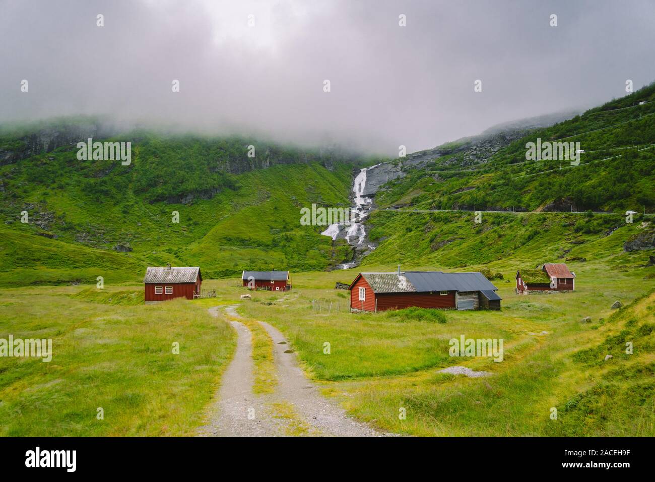 Capanna in legno baite di montagna in mountain pass in Norvegia. Paesaggio norvegese con tipici scandinavi tetto di erba Case. Villaggio di montagna con le case piccole Foto Stock