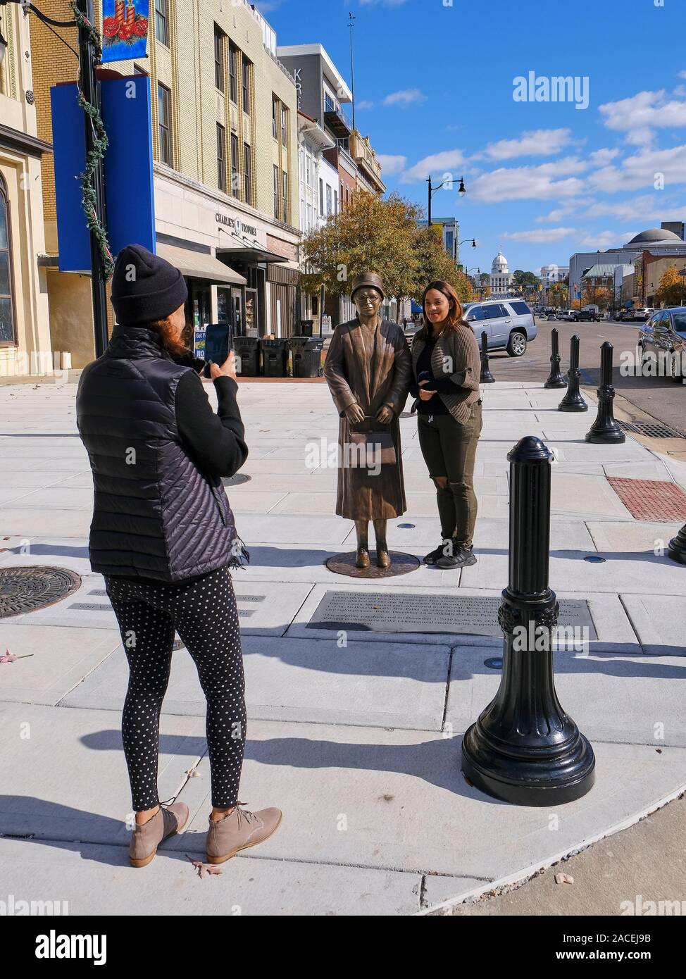 Afro-americano di donne posano per le foto con la Rosa Parks, diritti civili avvocato, statua in bronzo o marcatore storico a Montgomery in Alabama, Stati Uniti d'America. Foto Stock