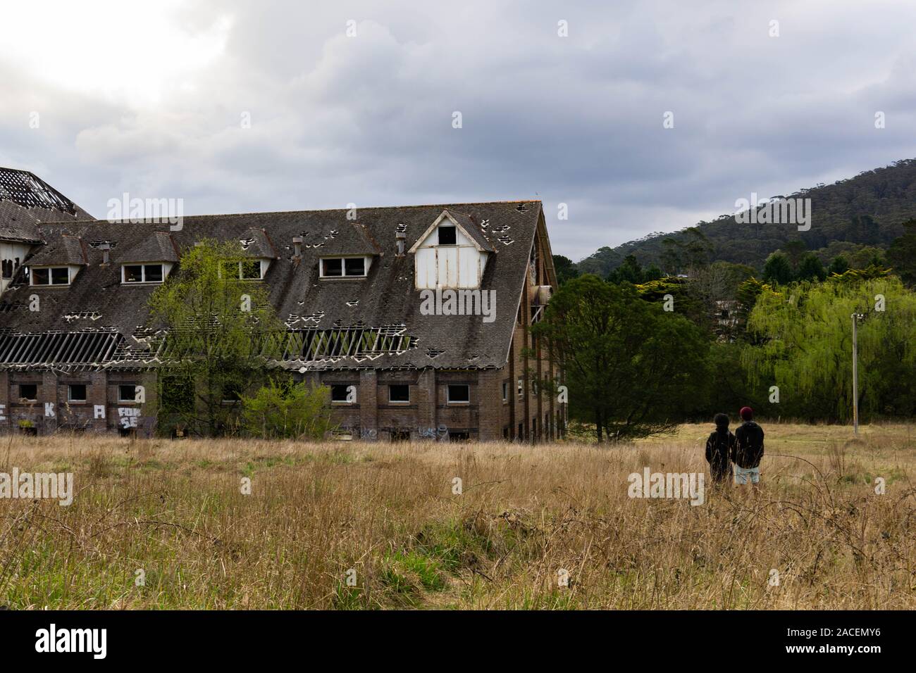 Esplorare giovane ammirando un edificio abbandonato Foto Stock