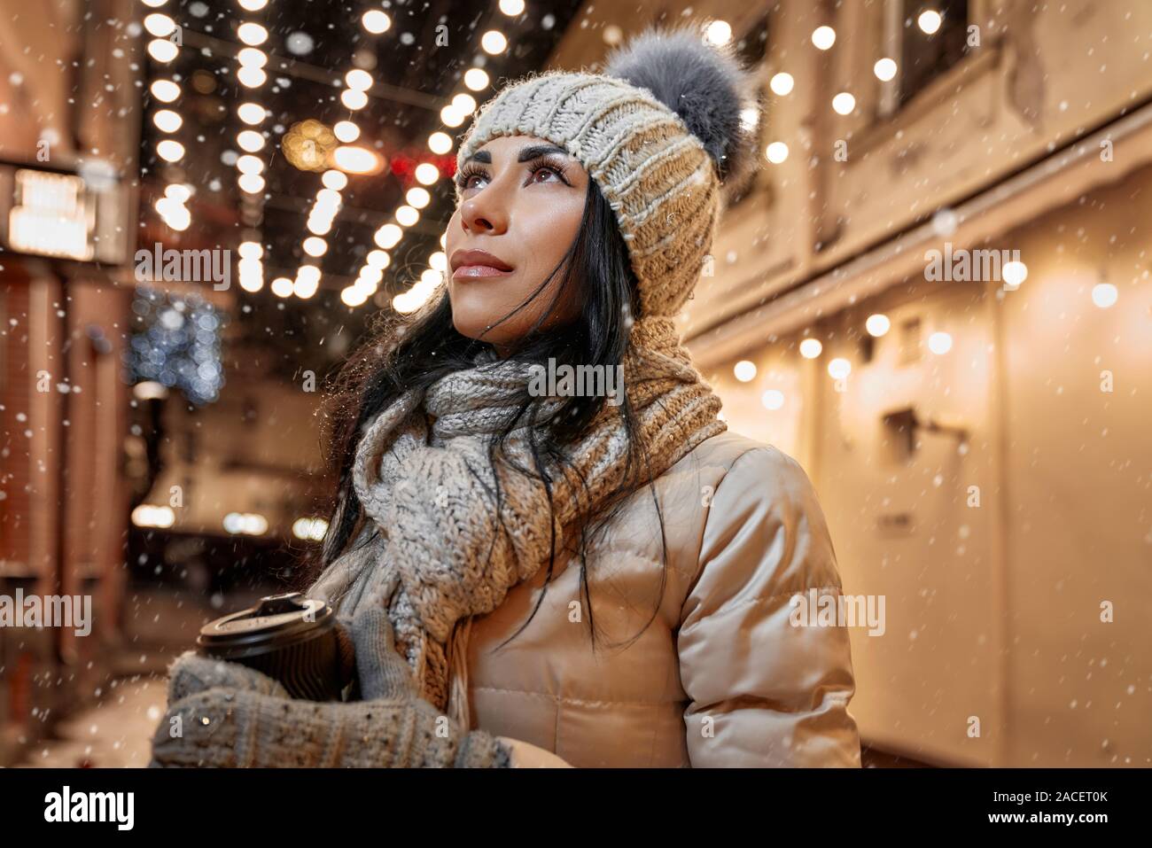 Ragazza in un caldo abbigliamento invernale sulla strada di sera. Bella  Signora in moderno con cappello