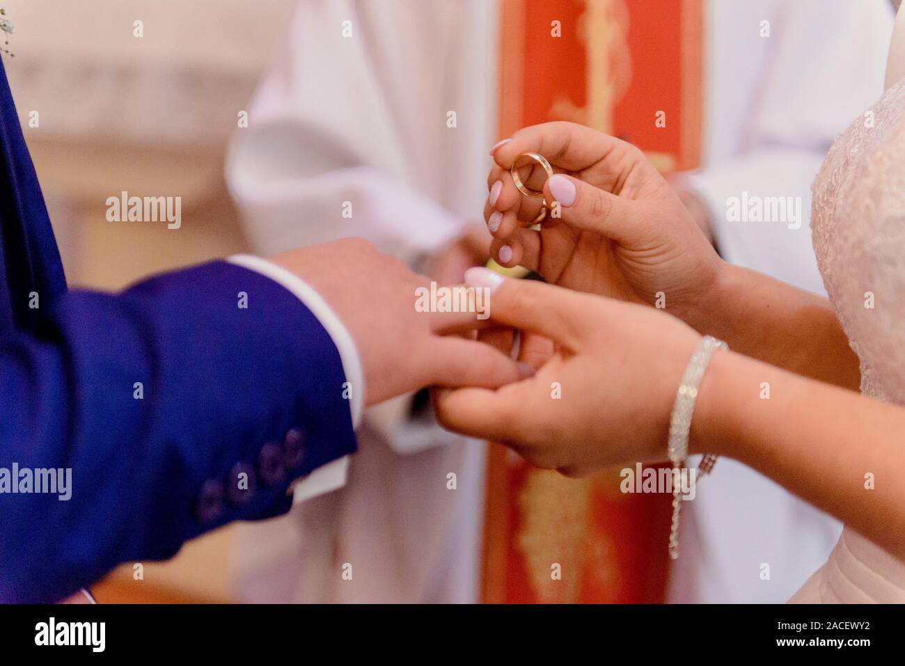 La sposa e lo sposo durante la cerimonia di nozze mettere gli anelli di nozze sulla loro dita. Foto Stock