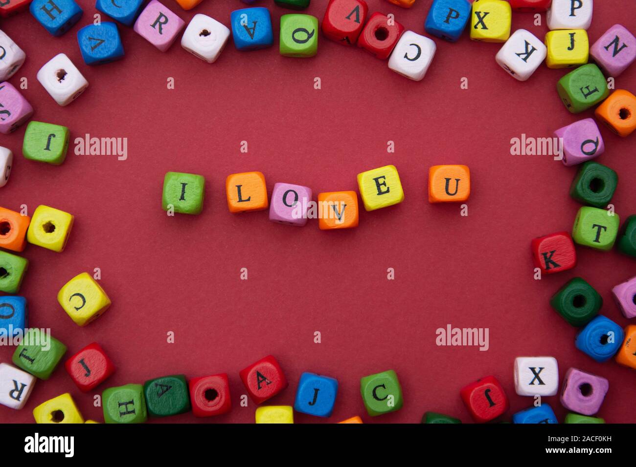 Ti amo parola, scritte su sfondo rosso. Il giorno di San Valentino, amicizia, Giornata della madre. Blocchi colorati parola d'amore. Foto Stock