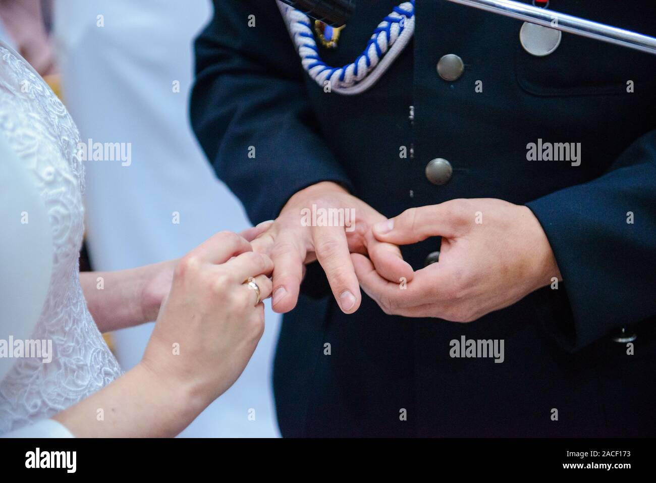 La sposa e lo sposo durante la cerimonia di nozze mettere gli anelli di nozze sulla loro dita. Foto Stock