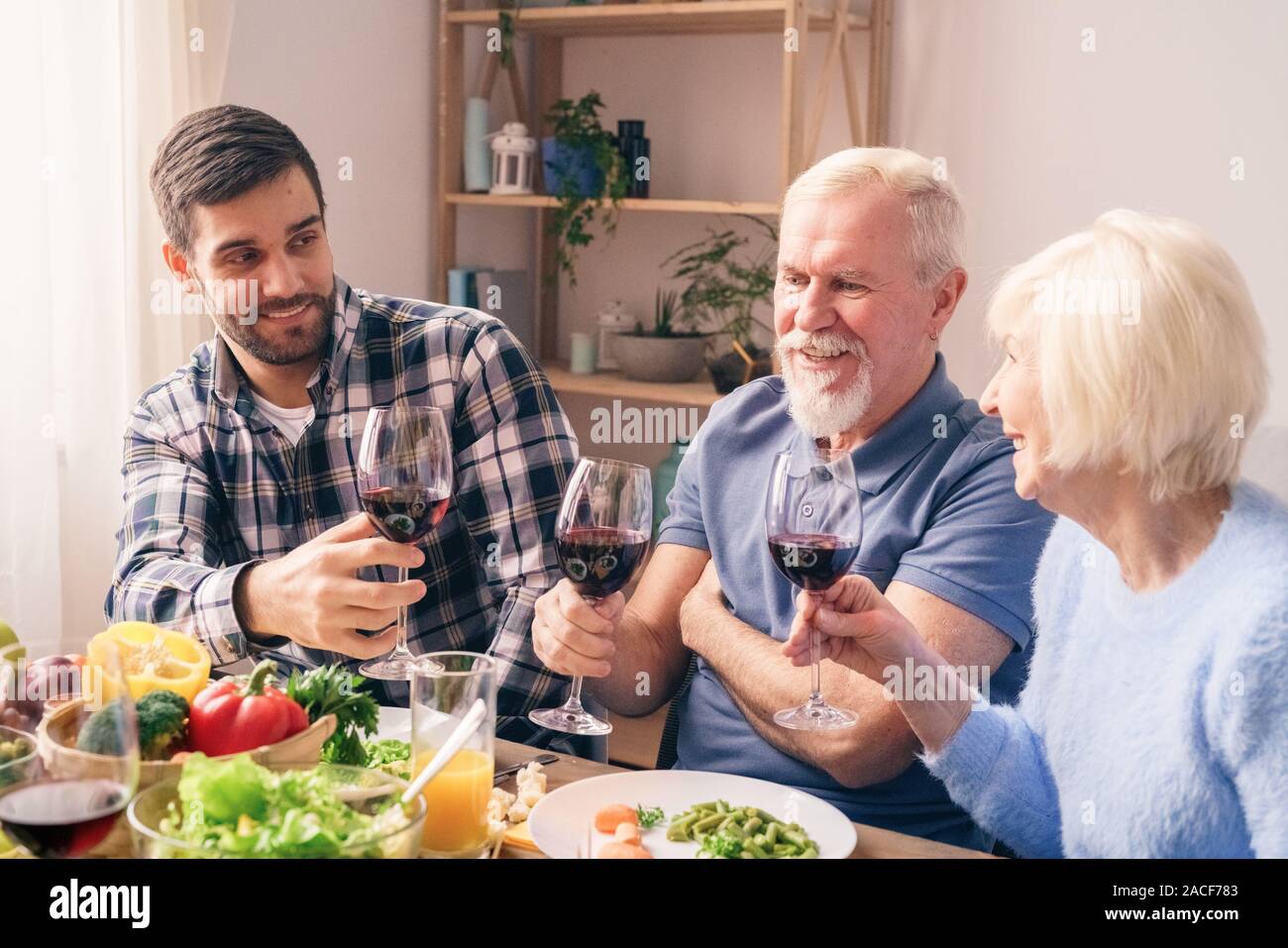 Figlio dire tostare per un anniversario del nonno e la nonna. Foto Stock