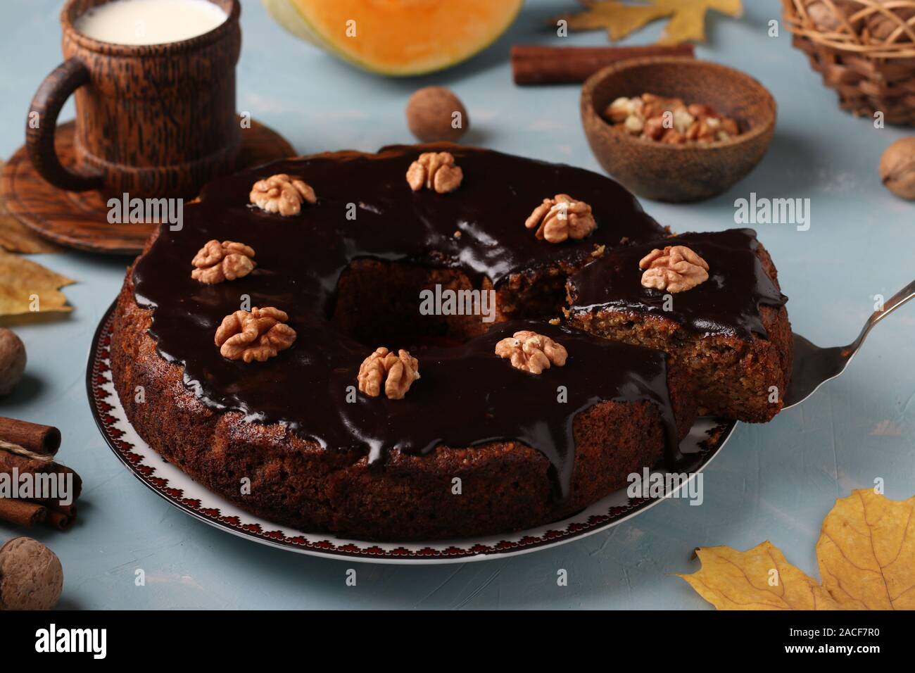 Fatti in casa muffin di zucca decorata con glassa di cioccolato e noci su un fondo azzurro, orientamento orizzontale Foto Stock