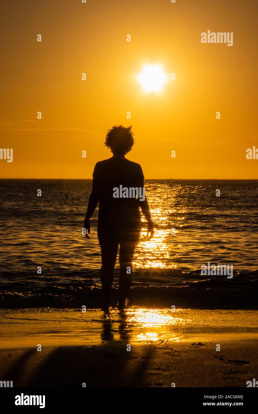 Silhouette di una donna in piedi sulla spiaggia al tramonto, Brasile Foto Stock