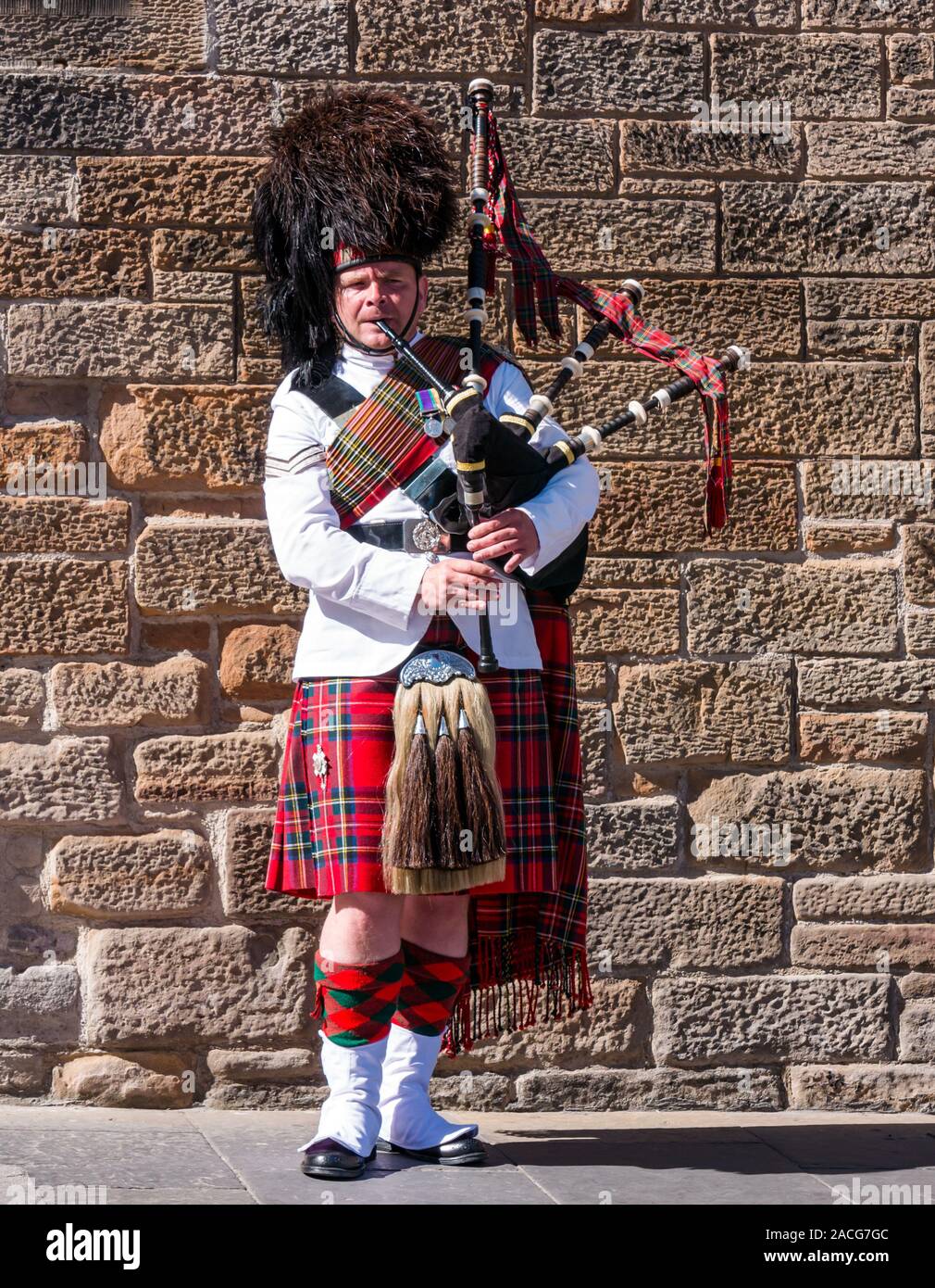 Lettore delle cornamuse busker indossa kilt e abiti uniforme, Royal Mile di Edimburgo, Scozia, Regno Unito Foto Stock