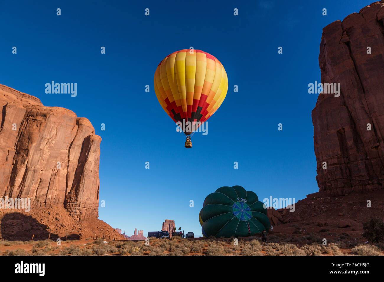 Una mongolfiera sorge nelle prime ore del mattino cielo in Monument Valley Balloon Festival nel parco tribale Navajo Monument Valley in Arizona. Anothe Foto Stock