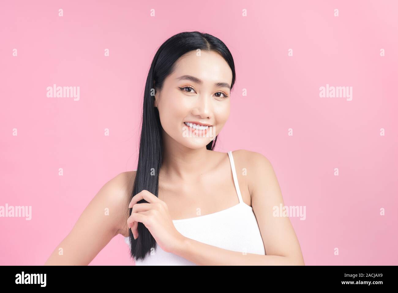 Attraente donna asiatica prendendo cura dei capelli Foto Stock