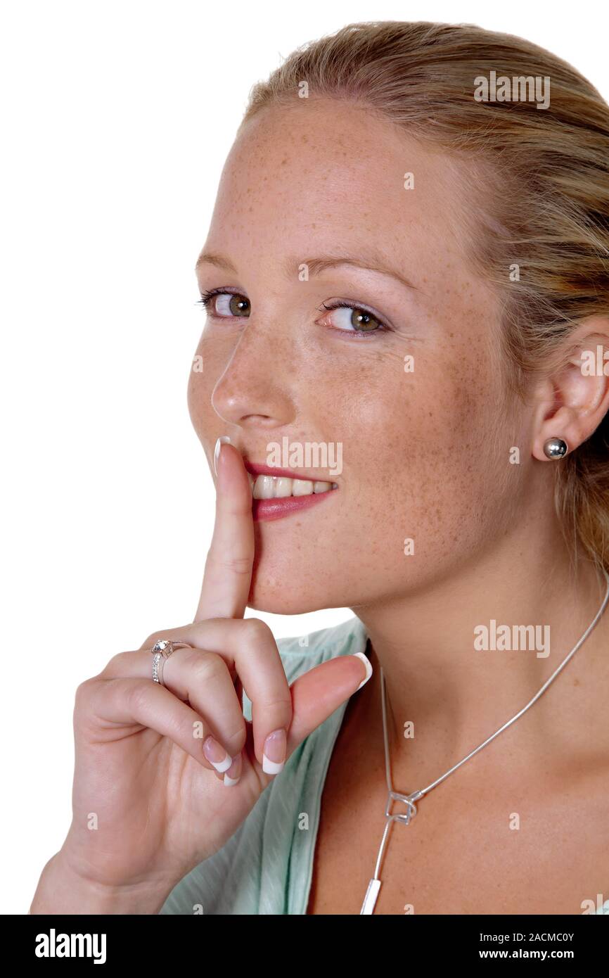 Donna con il dito sulla bocca Foto Stock