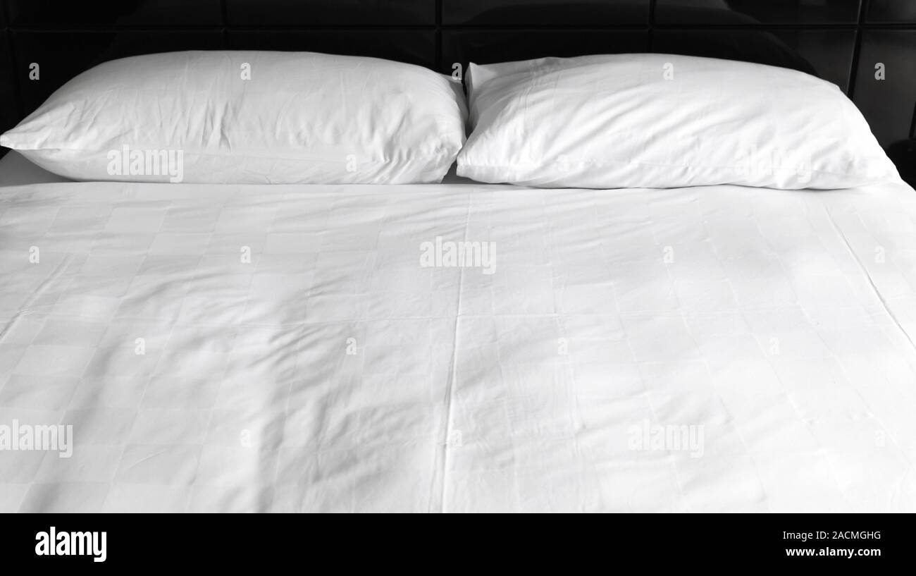 Due cuscini bianchi i laici a un letto vuoto, dormire tempo di sfondo foto, vista frontale Foto Stock
