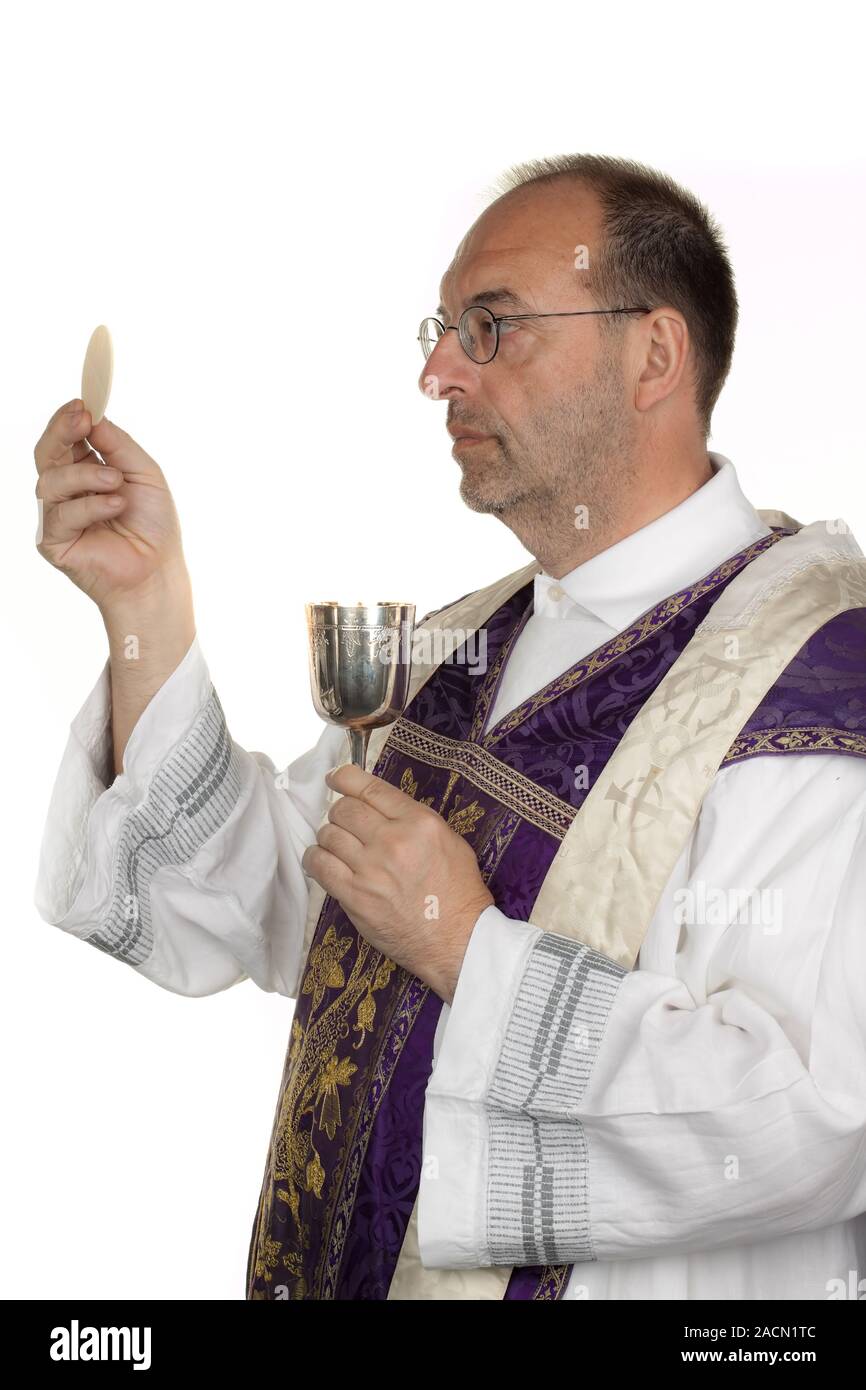 Sacerdote cattolico in comunione nel servizio divino Foto Stock