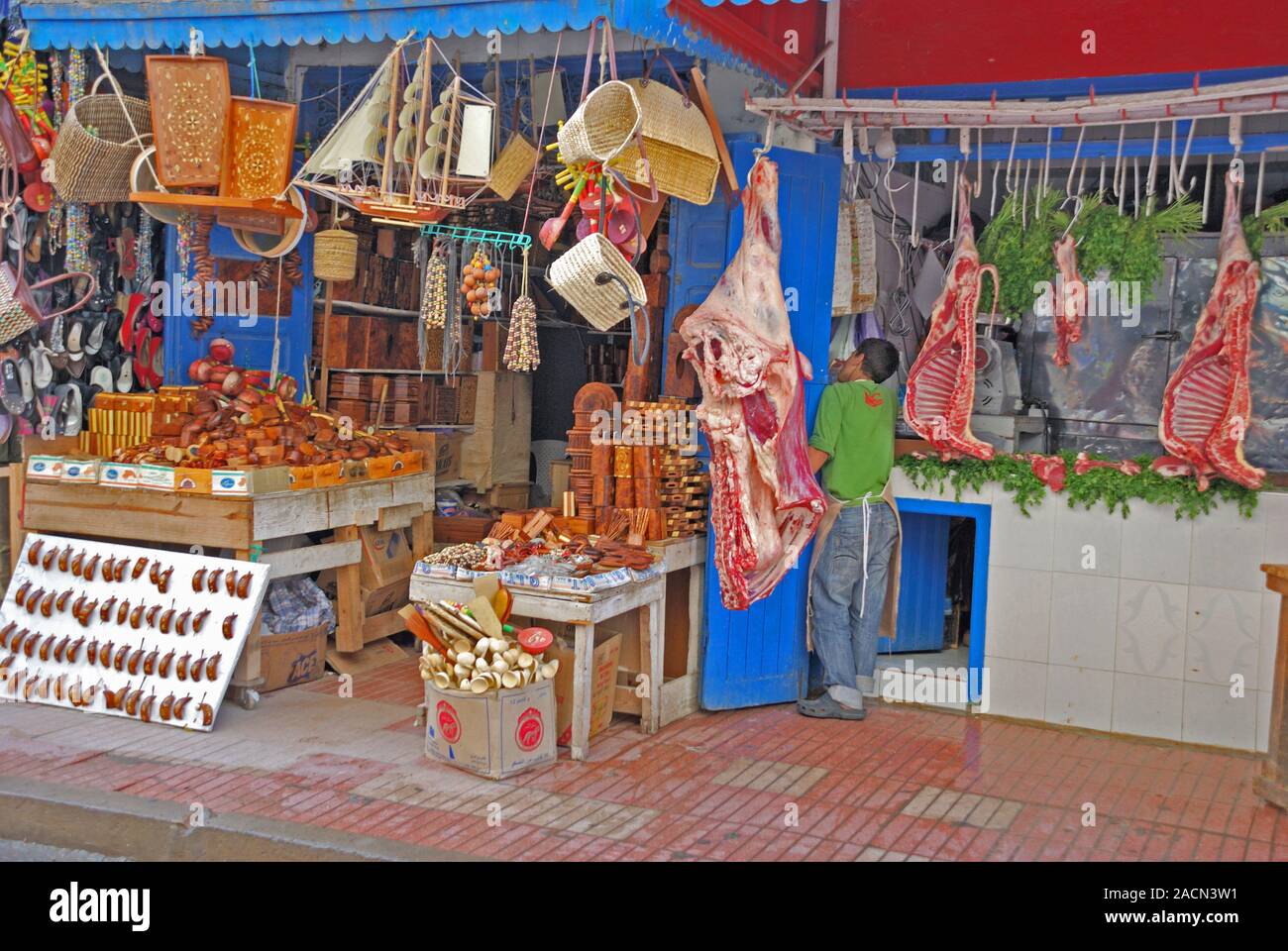 Macelleria e souvenir in stallo souk accanto a ciascun altro, Fez, in Marocco, Africa Foto Stock