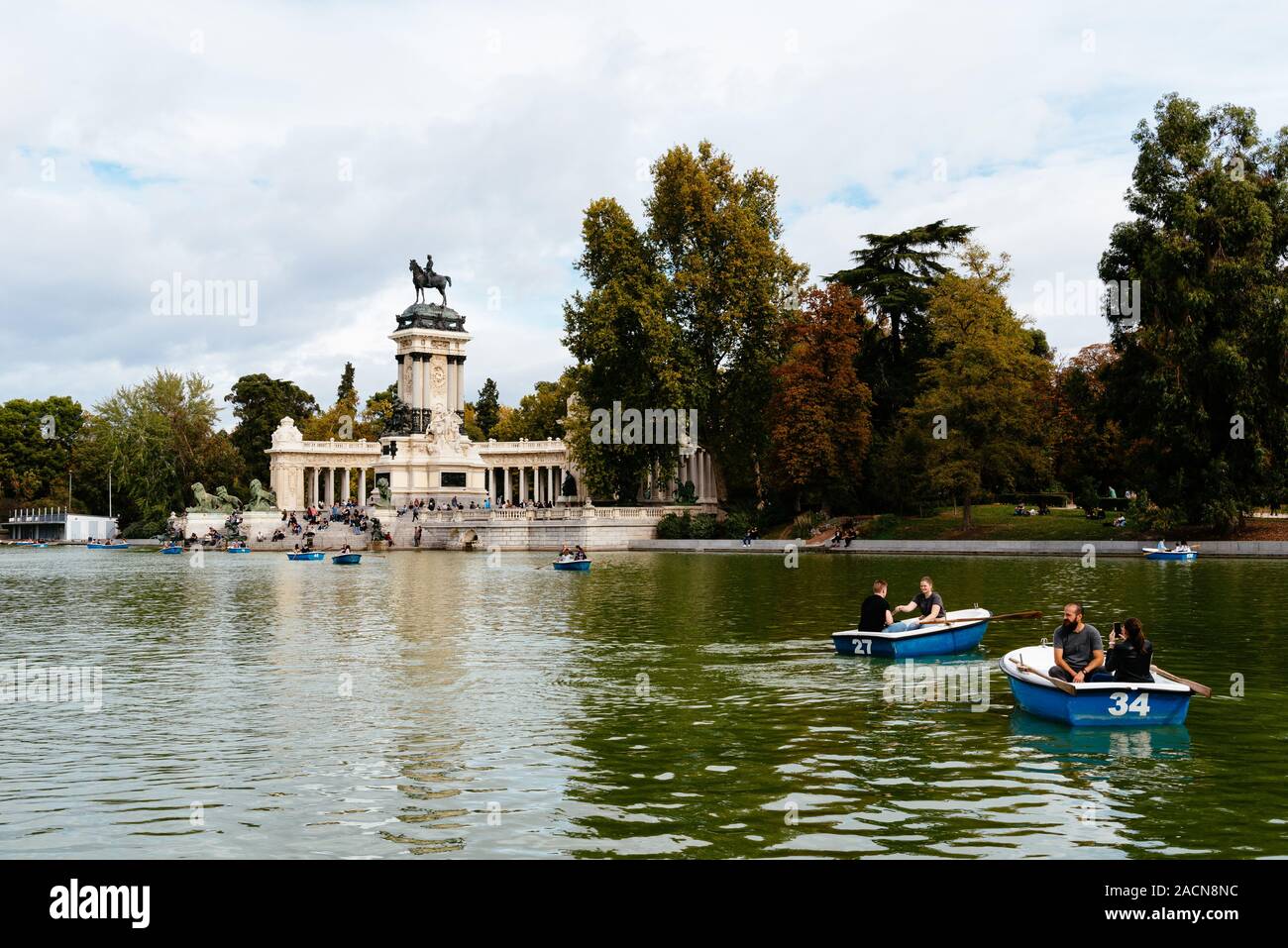 Madrid, Spagna - 1 Novembre 2019: persone in fila-barche nel grande stagno di Buen Retiro Park una soleggiata giornata d'autunno. Foto Stock