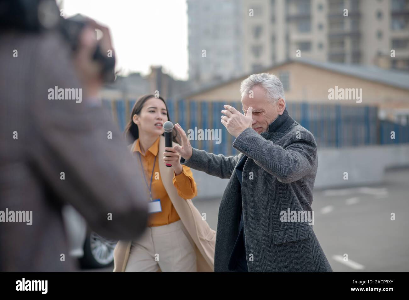 Reporters incontro famoso imprenditore accanto al suo ufficio Foto Stock