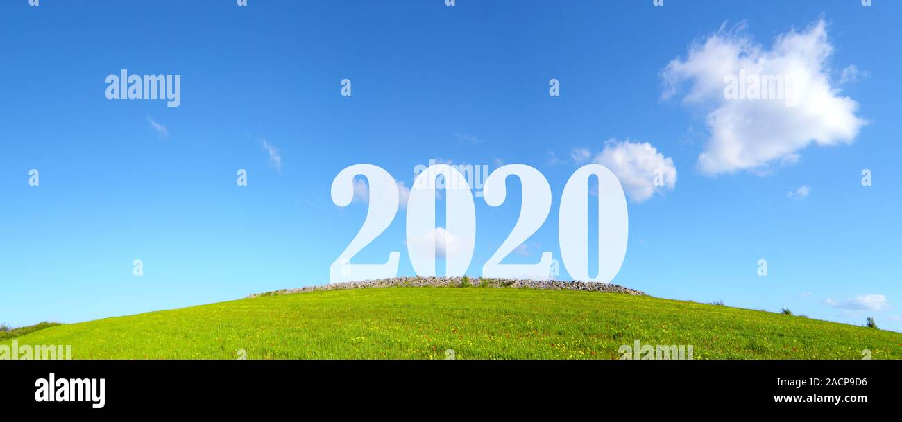 Green colina con 2020 iscritto sulla parte superiore e un bel cielo azzurro con qualche nuvola Foto Stock