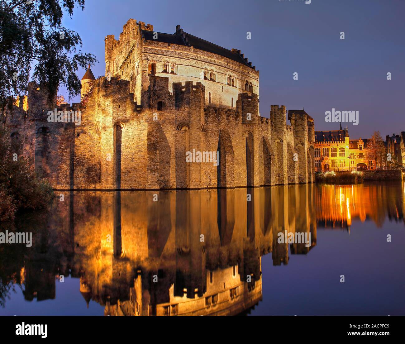 Castello illuminato Gravensteen al crepuscolo con acqua riflessione, moated castle, Gand, Fiandre, in Belgio Foto Stock