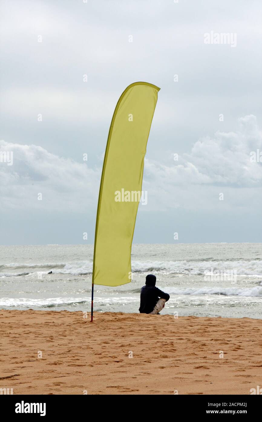 Bandiera e la persona sulla spiaggia Foto Stock