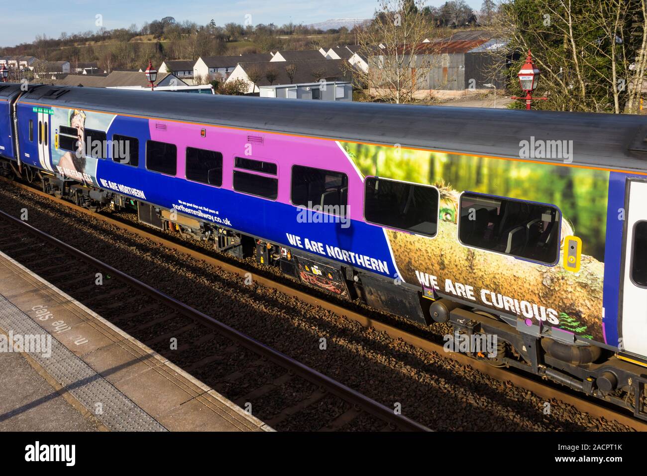Una sezione di una regione del nord della classe rampa 158 diesel multiple unit treni passeggeri con i loro "Siamo' settentrionale della campagna di marketing. Foto Stock
