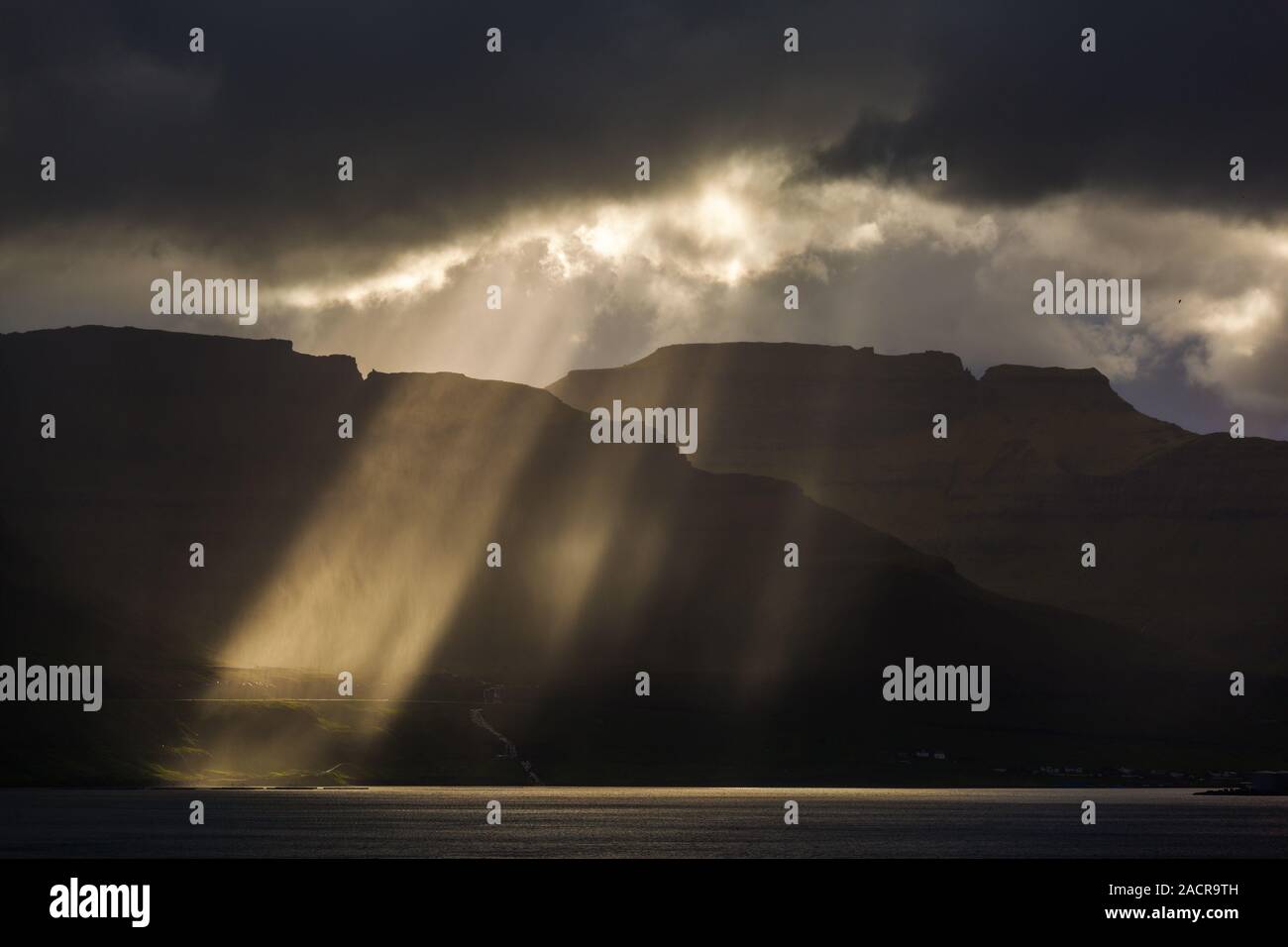 Sunbeam rompere attraverso le nubi sulle Isole Faerøer Foto Stock