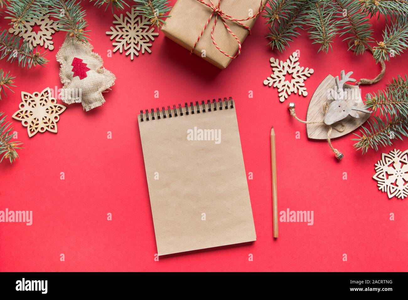 Zero rifiuti Nozione di Natale. Obiettivi, checklist, piani per il nuovo anno. La lista dei desideri, per fare la lista per il Nuovo Anno con legno arredamento naturale sul rosso. Vista dall'alto. Fla Foto Stock