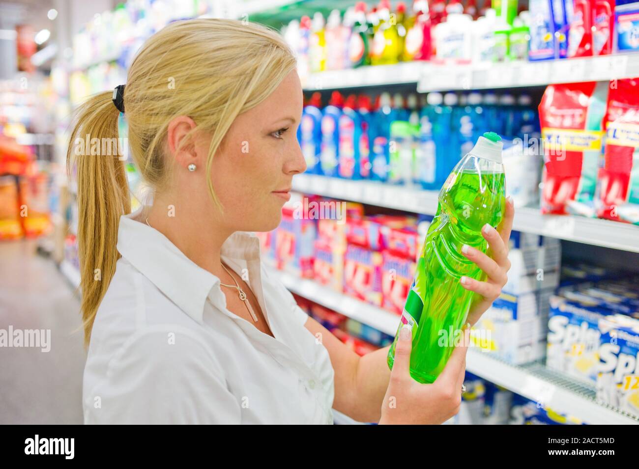 La donna acquista materiali per la pulizia in un supermercato Foto Stock