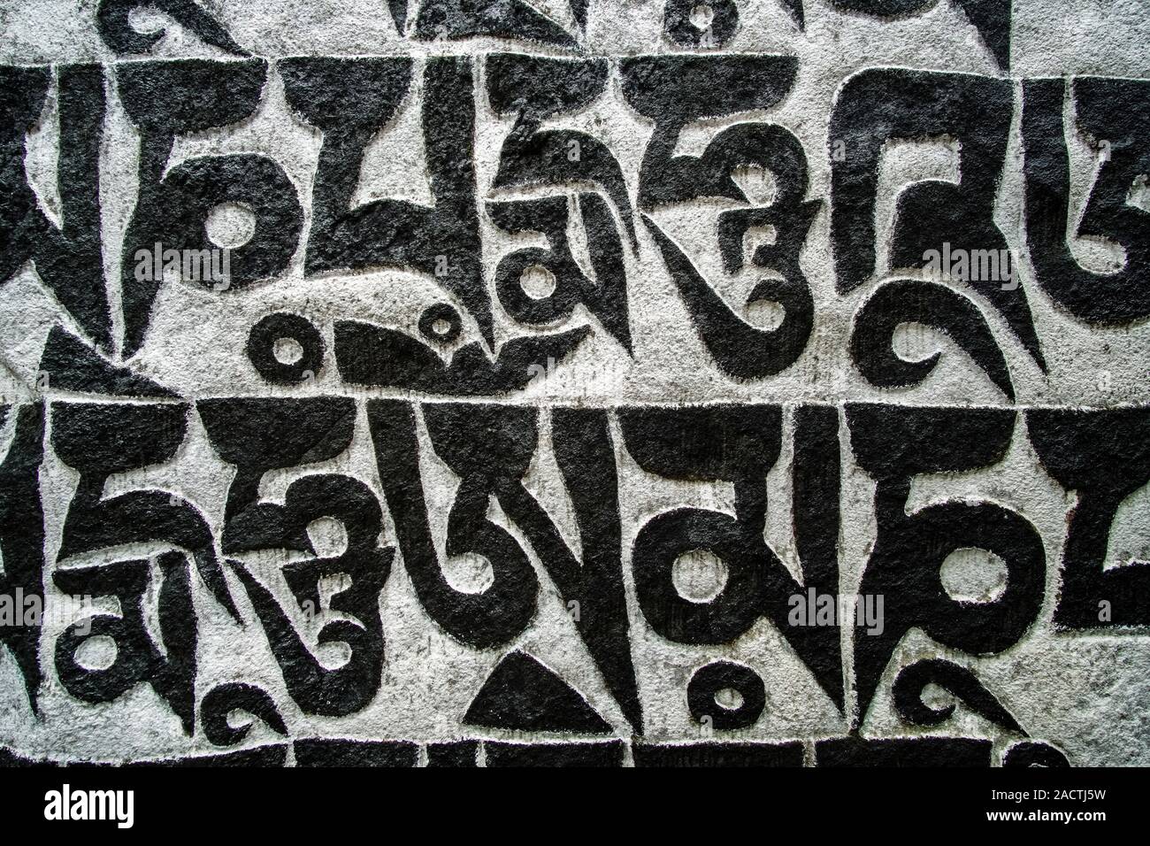 Mani di pietra con inciso il mantra tibetano OM MANI PADME HUM Foto Stock