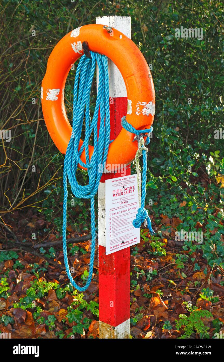 Un lifebelt e avviso pubblico dal pool di mulino sul fiume Bure a Guildford, Norfolk, Inghilterra, Regno Unito, Europa. Foto Stock