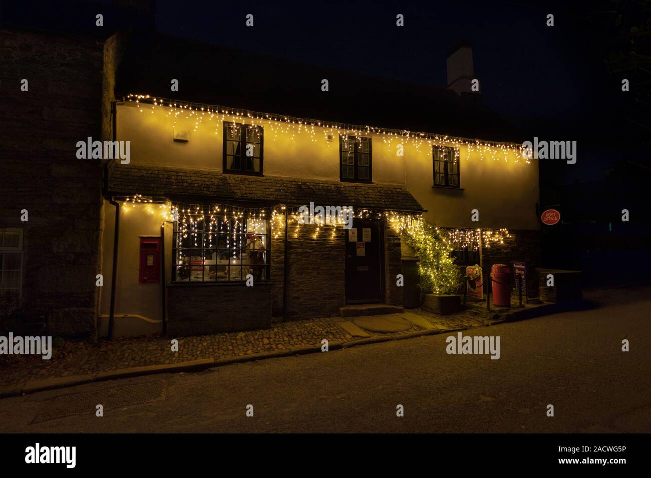 Stoke Climsland Post Office, la più antica di sub-Post Office nel Regno Unito. Primo giorno di inverno e le luci di Natale sono in alto Foto Stock