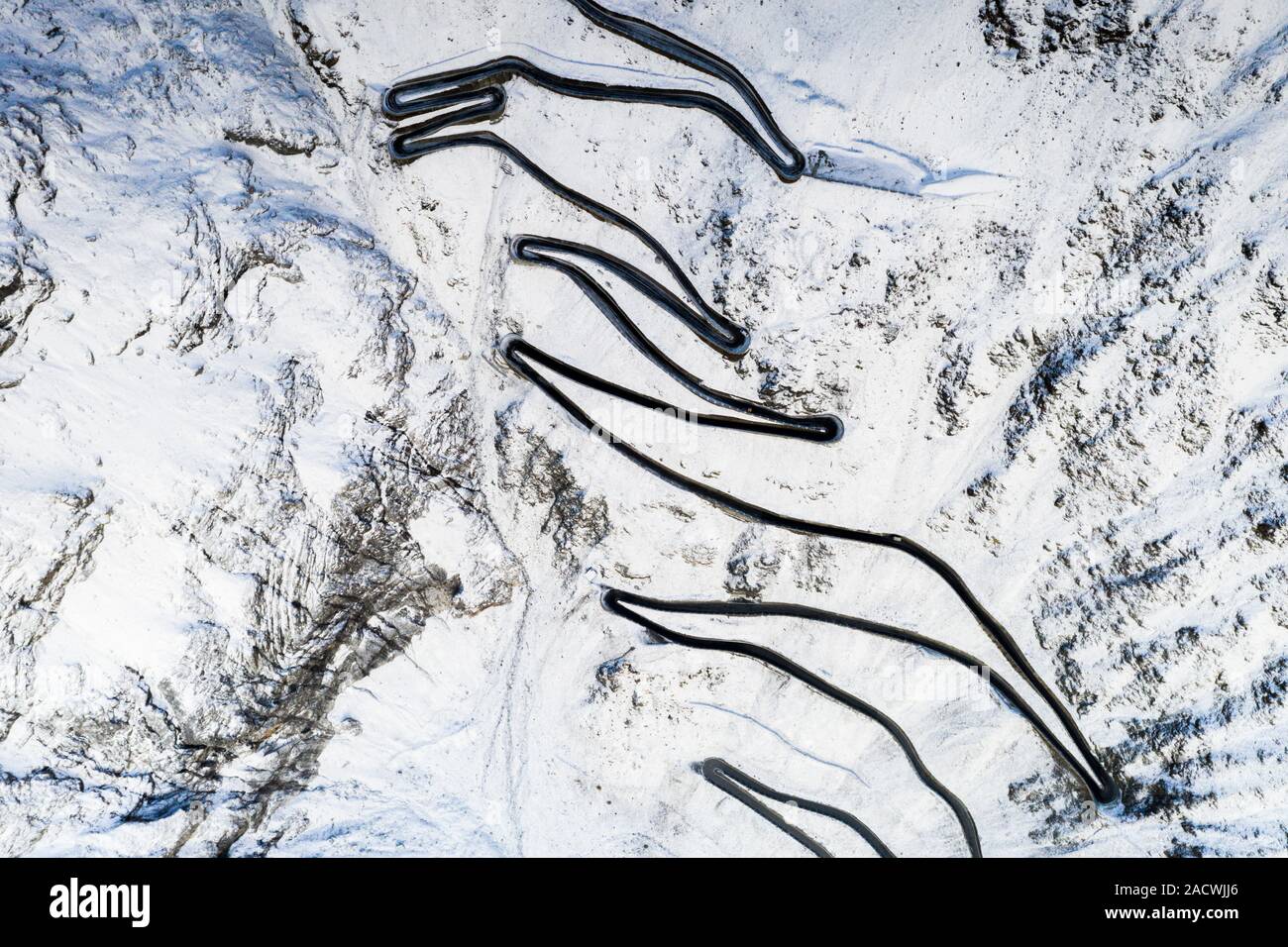 A zig zag forma e ripide curve della snowy strada dello Stelvio dal di sopra della provincia di Bolzano, Alto Adige, Italia Foto Stock