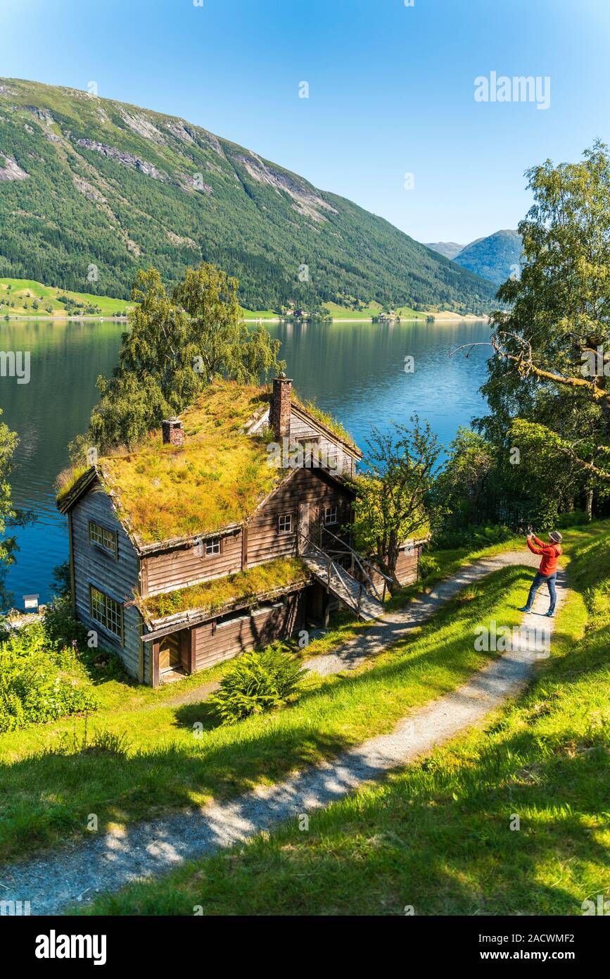 Uomo di fotografare la vecchia cascina con tetto di erba in Astruptunet, Jolster, Sunnfjord, Sogn og Fjordane county, Norvegia Foto Stock