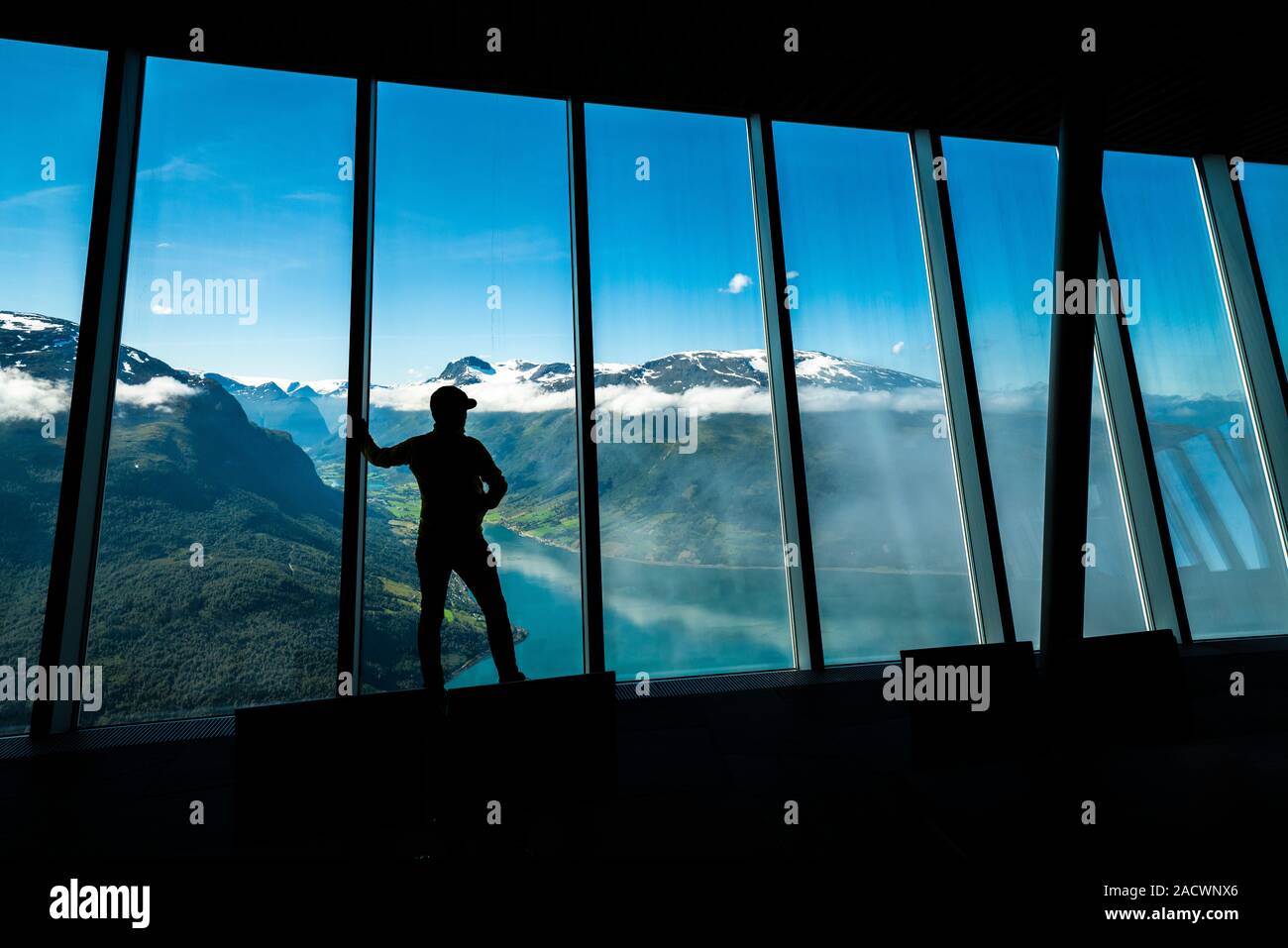 Silhouette di un uomo guarda fjord attraverso le finestre di vetro interno Hoven Ristorante, Loen, Stryn, Sogn og Fjordane county, Norvegia Foto Stock