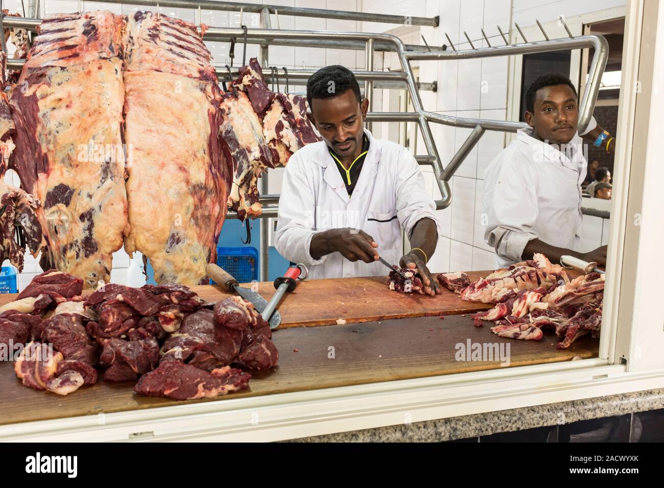 Butcher il taglio di carne a fette in una siga scommessa (un combinato di macellaio e ristorante) in Etiopia ad Addis Abeba Foto Stock