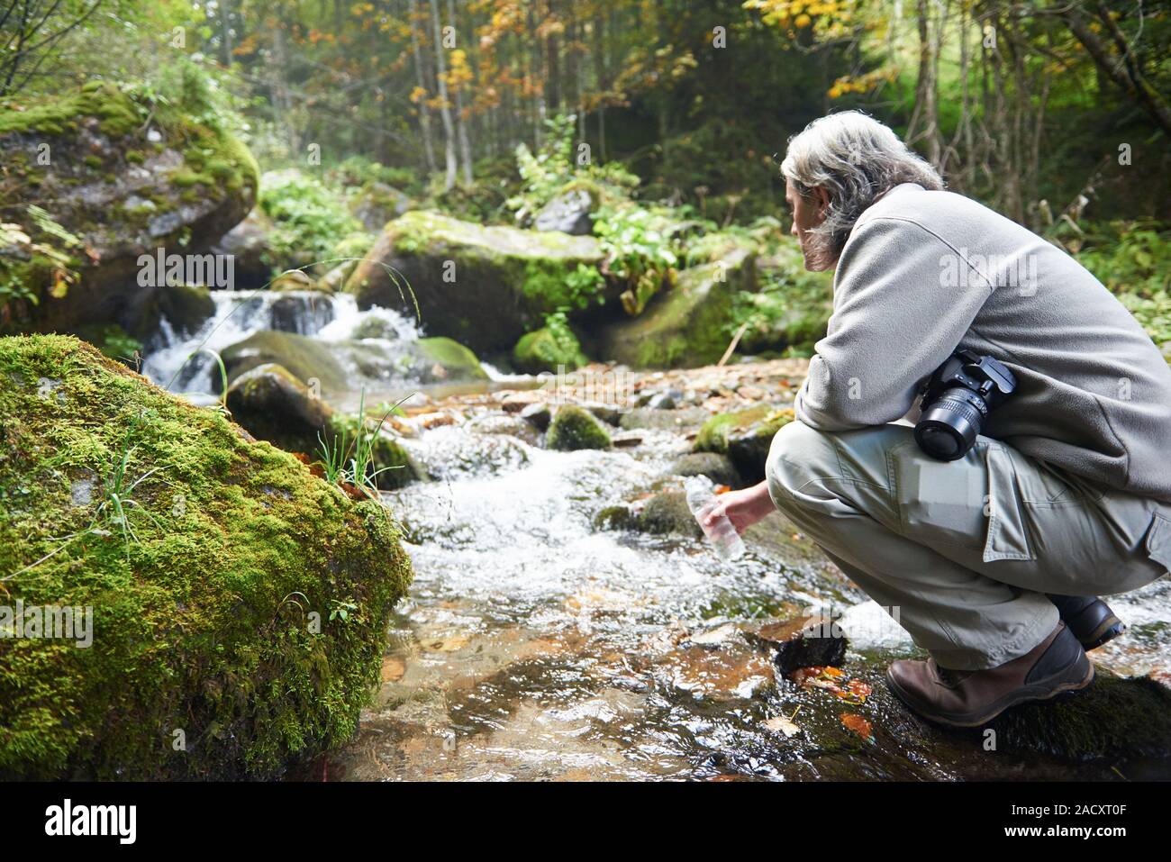 Uomo di bere acqua fresca da molla Foto Stock
