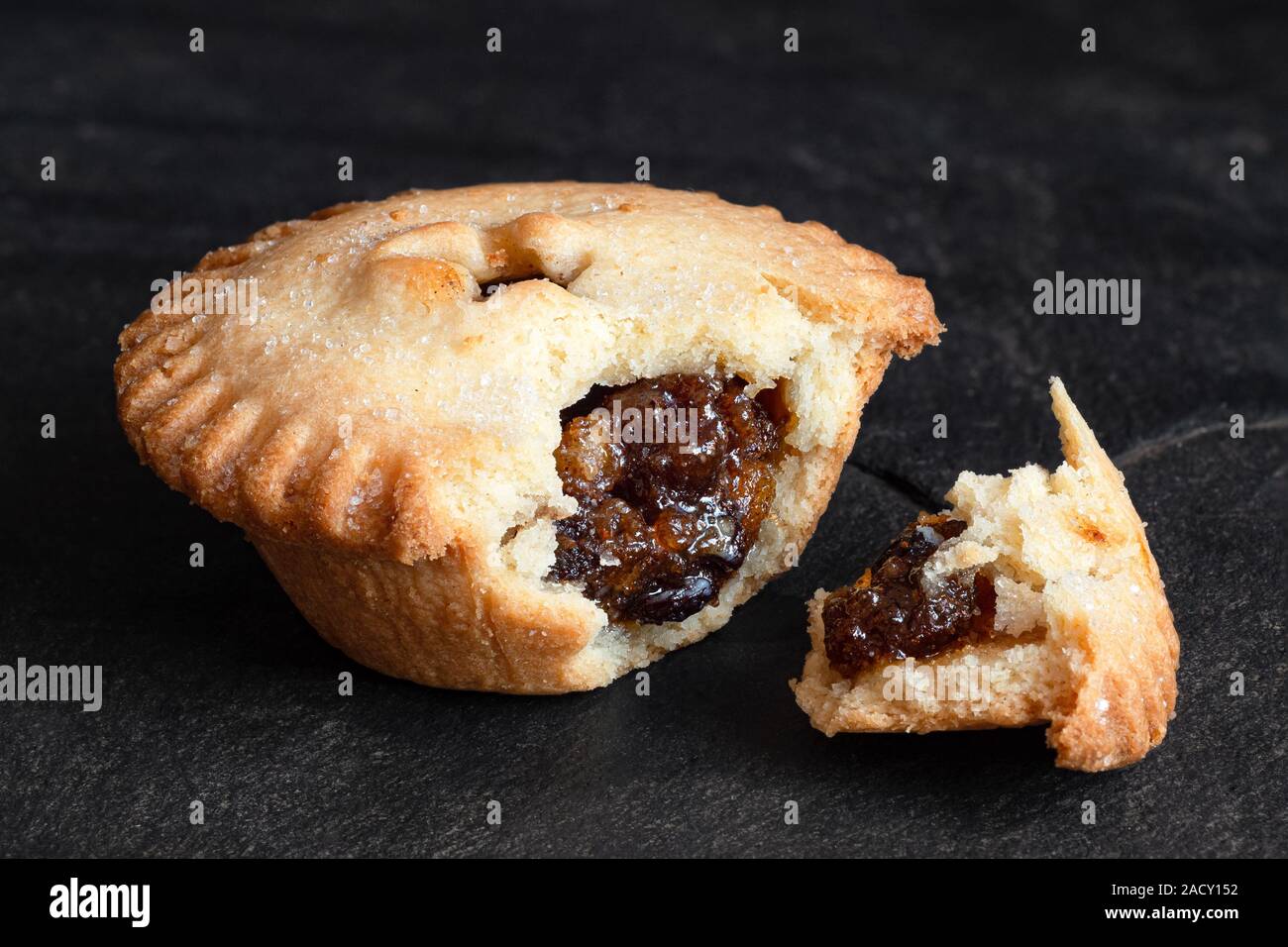 Aprire rotte tradizionali di Natale inglese tritare la torta con ripieno di frutta isolato su nero ardesia. Foto Stock