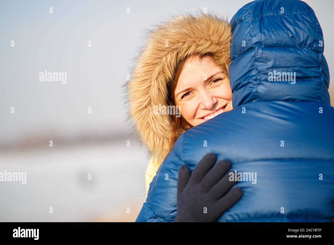 Felice coppia di maschio e femmina abbracciando ain inverno all'aperto Foto Stock